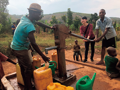A Japan Overseas Cooperation Volunteer (JOCV) giving instruction on well maintenance and management while drawing water with local residents in Rwanda (Photo: JICA)
