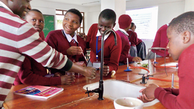 「Tanzanian female junior high school students attending a science class through the “Project for Establishing a Model School to Produce Women Leaders through Enhancement of Science and Mathematics and All-round Education” (Photo: JICA)
