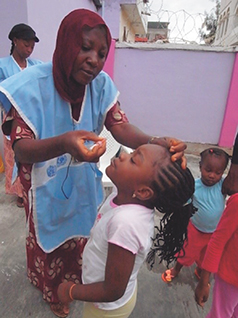 Administering an oral polio vaccine to a child (Photo: JICA)