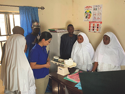 Ms. YOKOI Mizuho, head of the UNDP North-East Sub-Office, listens to healthcare providers describing the current situation at a reconstructed clinic in the village of Ngwom in Borno State, Nigeria. She worked at the UNDP Ghana Office through the JPO Programme until 2001.