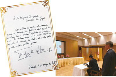 Mensaje de Sus Majestades los Reyes de España (izquierda) y el primer ministerio tailandés firmando en el libro de felicitaciones en la Embajada de Japón en Tailandia (derecha)