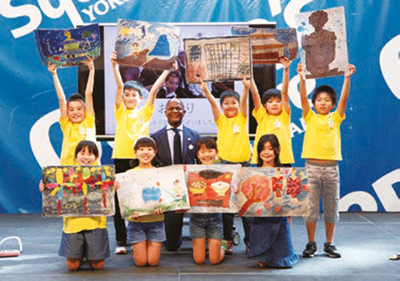 Estudiantes de primaria regalan un cuadro a un embajador africano en Japón / Programa de Yokohama “Una escuela, un país”, (27 de agosto) (foto facilitada por la ciudad de Yokohama, (arriba)