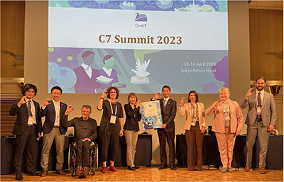C7 Summit participants pose for a commemorative photo with their right hand making the letter “C” (April 13, Tokyo)