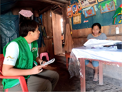 Going door-to-door to interview members of the women's self-governing committee of a village near the protected area (the author is on the left)