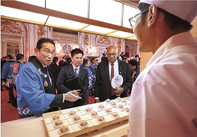 Prime Minister Kishida and Prime Minister Sitiveni Ligamamada Rabuka of Fiji visiting the stall of a Japanese confectioner from Ishikawa Prefecture at the “summer festival” (July 17, State Guest House, Akasaka Palace, Tokyo; Photo: Official Website of the Prime Minister of Japan and His Cabinet)