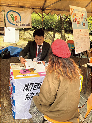Responding to inquiries at a booth during visiting service (Photo: Kansai NGO Council)