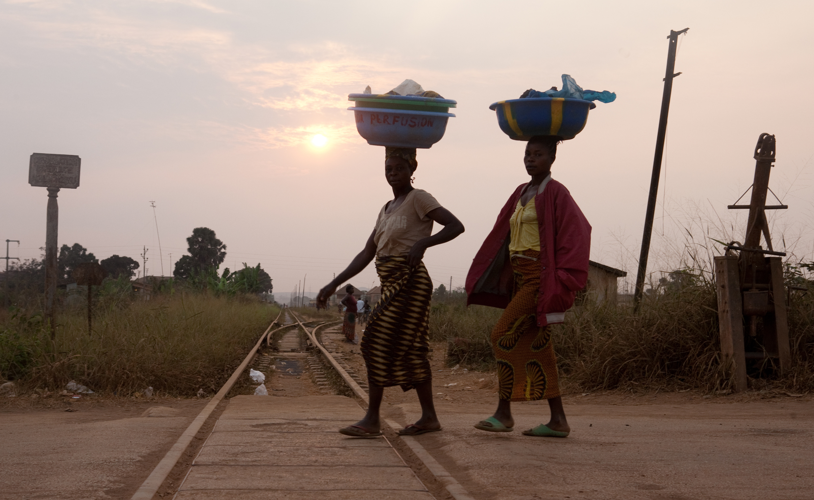 Two women carrying luggage overhead