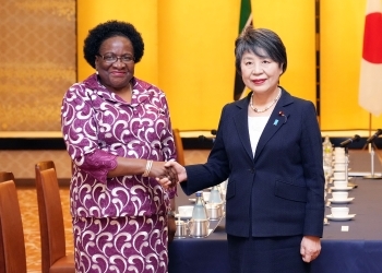 Two Ministers who shake hands facing straight at a camera