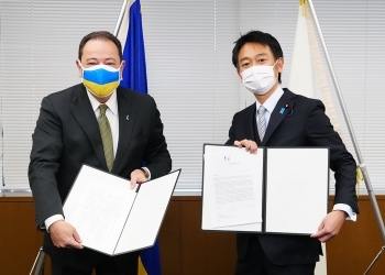正面を向き、交換した書簡を提示する、上杉外務大臣政務官とコルスンスキー駐日ウクライナ大使の様子